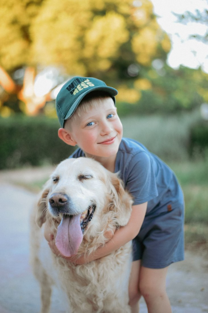 Enfant souriant qui câline un golden retriever